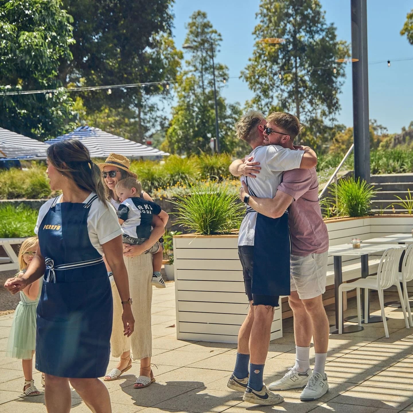 A Perry's team member welcoming a family and two friends hugging on the forecourt